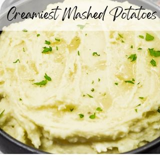 A bowl of creamy mashed potatoes garnished with chopped herbs, with the text "Creamiest Mashed Potatoes" at the top.