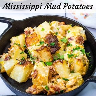 Two pans of Mississippi Mud Potatoes topped with cheese and herbs, served in a black bowl.