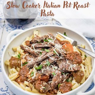 A bowl of pasta topped with shredded pot roast, tomatoes, and herbs, garnished with grated cheese. Text above reads "Slow Cooker Italian Pot Roast Pasta." A white and blue tile background.