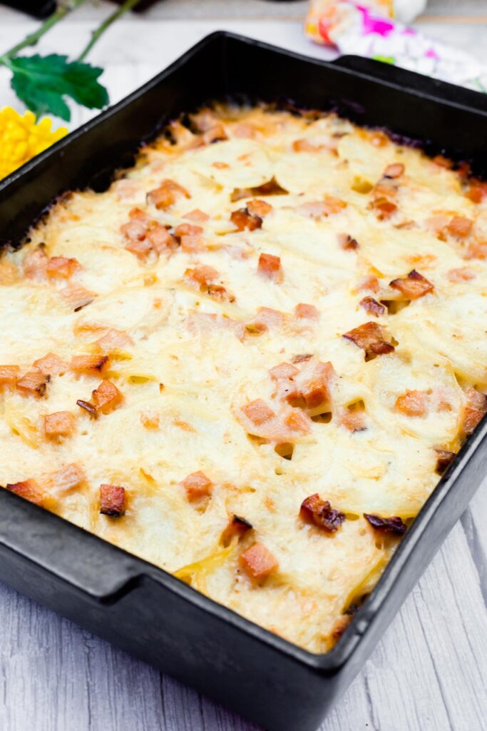 A baked dish of Scalloped Potatoes with Ham and Cheese in a rectangular baking pan.