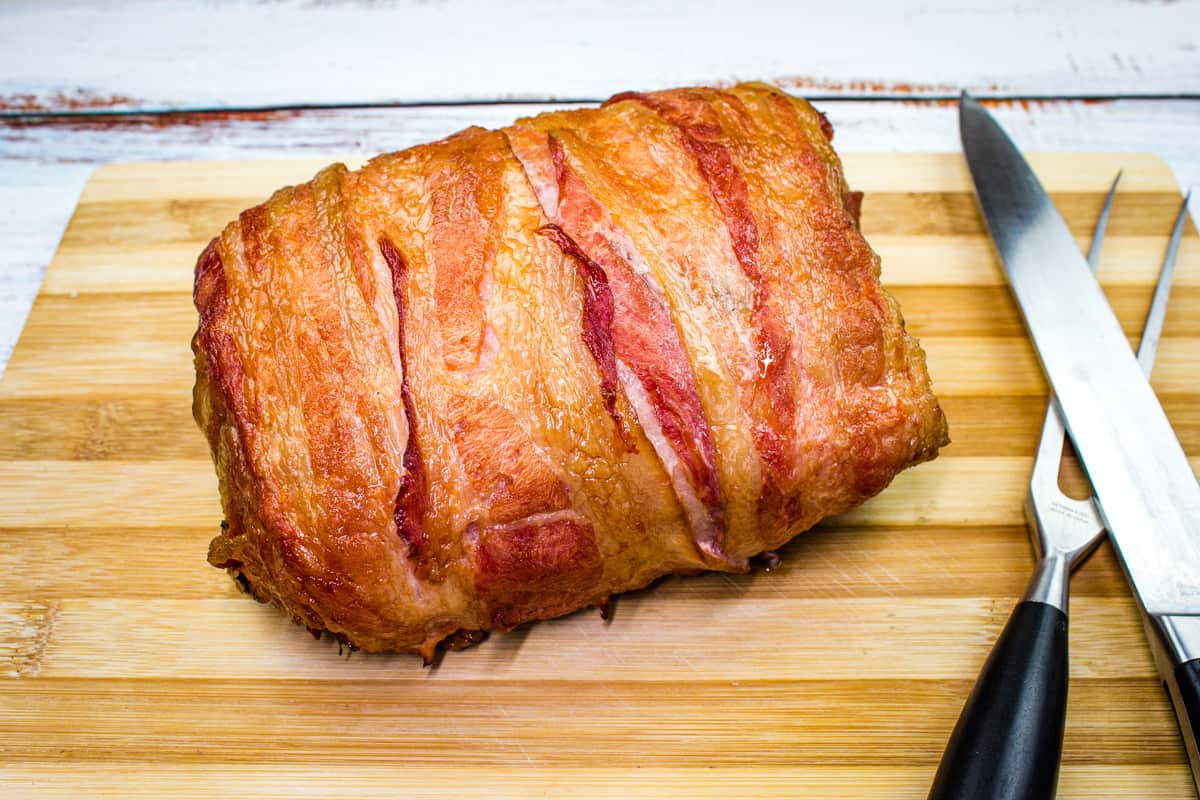 Smoked ham on a wooden cutting board.