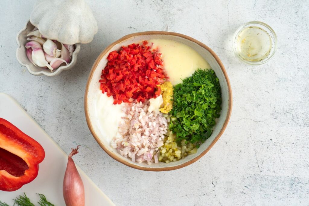 Mixing ingredients for dressing in a bowl for Creamy Red Potato Salad with Pickle.