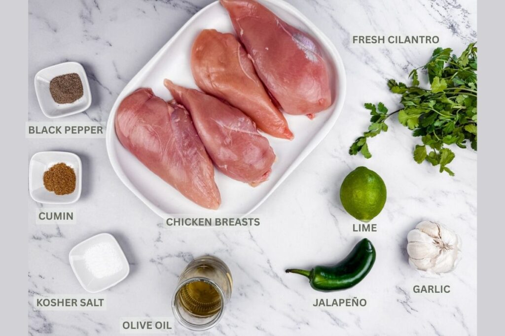 Raw chicken parts, Cilantro, lime, Jalapeno, garlic, oil, salt, cumin powder and black pepper on the surface with names