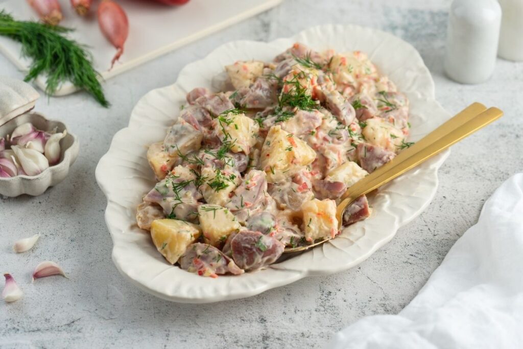 Horizontal image of delicious Creamy Red Potato Salad with Pickle.