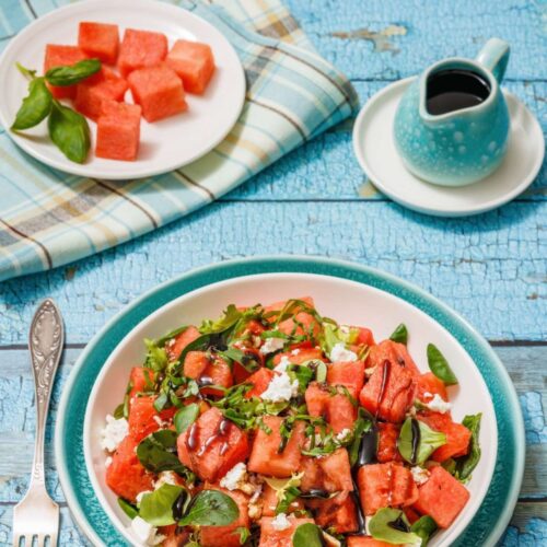 A plate of Watermelon Salad with Balsamic Glaze and Feta beside a fork.
