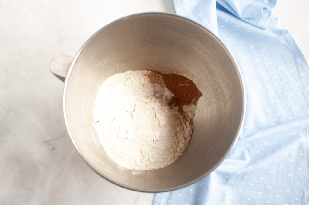 Overhead shot of gluten-free flour and other dry ingredients in a metal mixing bowl.