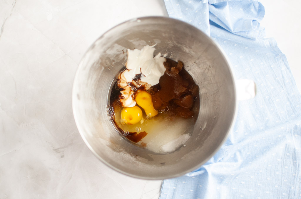 Overhead shot of wet ingredients for carrot muffins in a metal mixing bowl before being combined.