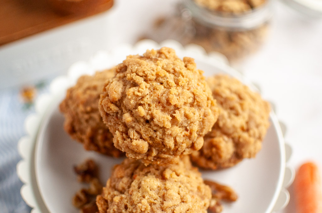 A stack of golden-brown Carrot Muffins on a white plate.