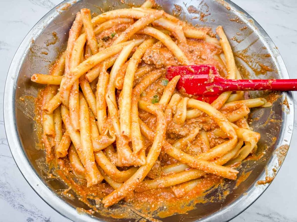 Mixing the ziti with the mixture for Classic Baked Ziti.