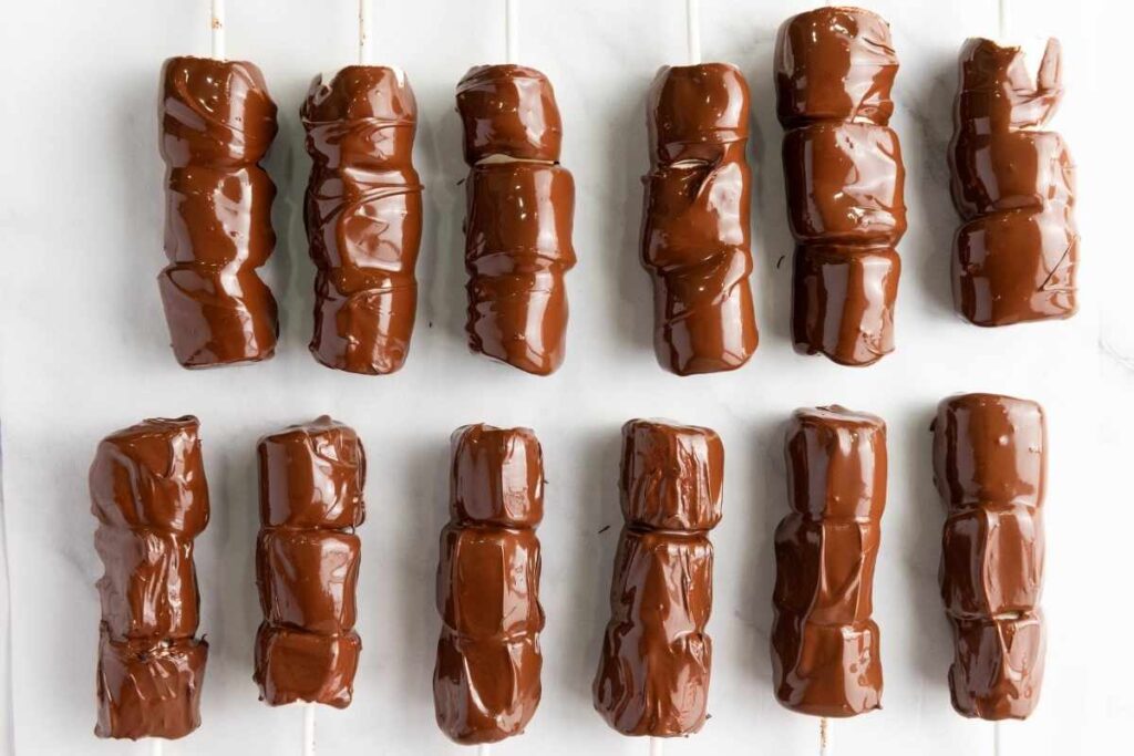 Chocolate-coated marshmallows neatly lined up in a row.